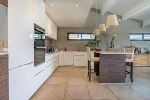 a kitchen with white cabinets and a table with chairs at House 5p with garden in the heart of Saint-Raphaël in Saint-Raphaël +18 photos