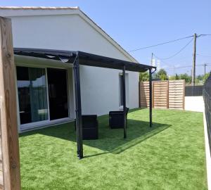 awning on a lawn in front of a house at LA NUIT DES SECRETS Love Room 4 étoiles avec Jacuzzi et Sauna in Roquebrune-sur-Argens