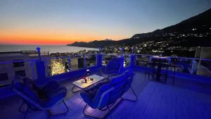 a balcony with blue chairs and a table and the ocean at Elma Apartments Dobra Voda in Dobra Voda