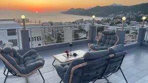 a balcony with chairs and a table and a view of the ocean at Elma Apartments Dobra Voda in Dobra Voda