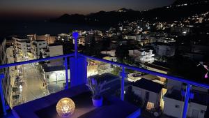 a view of a city at night from a balcony at Elma Apartments Dobra Voda in Dobra Voda