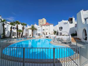 a swimming pool in a resort with white buildings at Casas Blancas Las Tortugas in Playa de las Americas