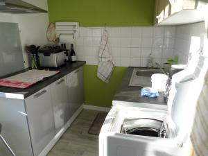 a kitchen with a sink and a washing machine at bord de rivière in Accons +1 photo