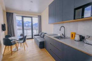 Babex Panorama في باكورياني: مطبخ وغرفة معيشة مع أريكة وطاولة