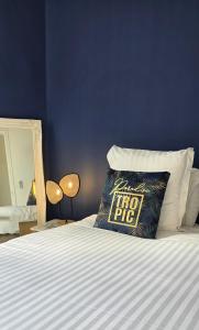 a blue room with a bed with a pillow with a floor rug at Hôtel de la Fontaine in Nice +69 photos