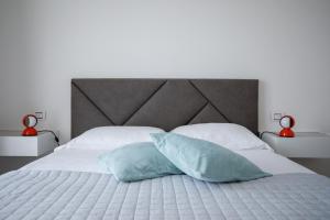 a bedroom with a white bed with two pillows at IseoLakeRental - Monti e Lago in Solto Collina