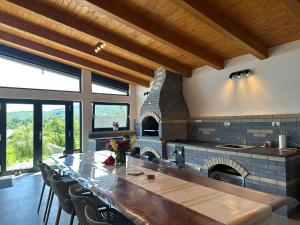 a large kitchen with a long table and a fireplace at A Green Nest in Suceava