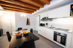 a kitchen with a table with a bowl of fruit on it at Maison Selva - Palazzo Cervi Duplex Superior in Salò