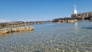 a body of water with a lighthouse in the background at Meraviglia d'Otranto in Otranto