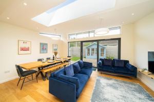 a living room with a table and a blue couch at Newhall Gardens in Invergowrie