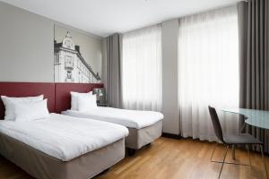 a hotel room with two beds and a table at Original Sokos Hotel Albert in Helsinki