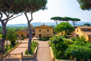 a view of a garden with trees and buildings at Casone Ugolino in Donoratico