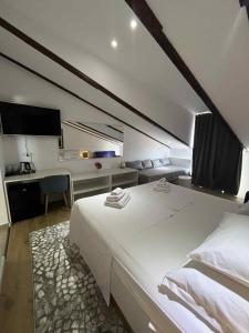 a bedroom with a large white bed and a desk at Dela in Hvar