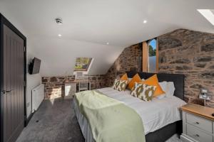 a bedroom with a bed and a stone wall at The Stables in Dundee