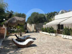 a courtyard with a couch and a building at Dimora Tesoro - by Cala Salento in Torre Lapillo