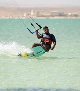 a man on a surfboard in the water at استراحة القمة in Ḩilf