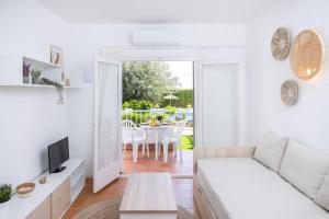 a white living room with a white couch and a table at RVApartaments Escala Brava in L'Escala