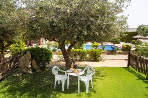 a table and chairs in a yard with a tree at RVApartaments Escala Brava in L'Escala