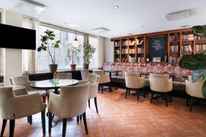 a dining room with tables and chairs and bookshelves at Original Sokos Hotel Albert in Helsinki +15 photos