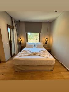 a large bed in a room with a window at ΝΕΑΚΙΤΟΣ Luxury Apartments in Nikiti