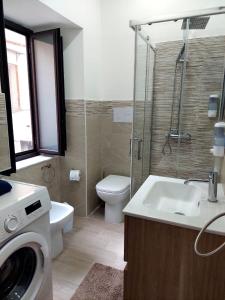 a bathroom with a toilet and a sink and a washing machine at Sweet dreams AF in Palermo