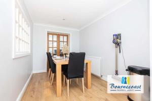 ein Esszimmer mit einem Holztisch und schwarzen Stühlen in der Unterkunft MADEIRA MEWS by BOURNECOAST - A Town Centre Home with Outside Decking and Parking - HB9635 in Bournemouth