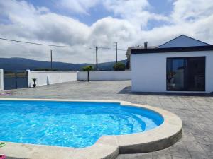 a large blue swimming pool in front of a house at O barco de Coto in Barreiros