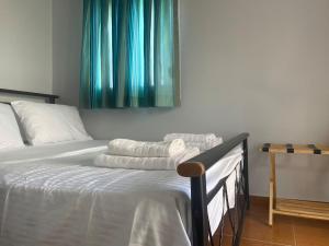a bed with white sheets and blue curtains in a room at Vasilakis Apartments 3 in Chios