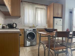 a kitchen with a washing machine and a table and chairs at Vasilakis Apartments 3 in Chios