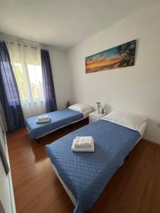 a bedroom with two beds with towels on them at Apartmani Dolores in Kaštela