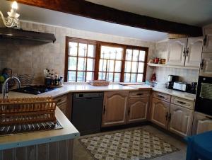 a kitchen with wooden cabinets and a counter top at Villa provençale climatisée, piscine chauffée, vue magnifique in Plan-de-la-Tour