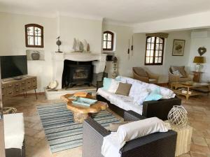 a living room with a couch and a fireplace at Villa provençale climatisée, piscine chauffée, vue magnifique in Plan-de-la-Tour