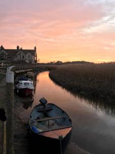 滨海克雷Lovely quiet cottage Sleeps 4 adults, 4 children, Dog Friendly的日落时分,两艘船停靠在河上