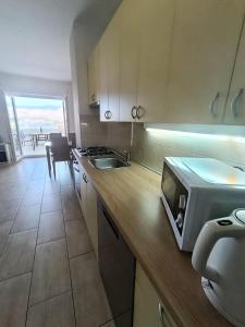 a kitchen with a counter with a microwave and a table at Apartments Višnja in Pag +18 photos