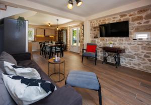 a living room with a couch and a tv on a stone wall at Haus Meter in Donji Proložac - Haus für 6 Personen in Donji Proložac