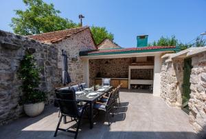 a patio with a table and chairs in a stone building at Haus Meter in Donji Proložac - Haus für 6 Personen in Donji Proložac
