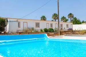 a swimming pool in front of a house at Quinta da Ponte in Odiáxere