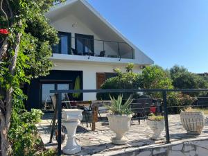 a house with a balcony with potted plants in front of it at Daskalis House # Даскаловата Къща in Alexandroupoli