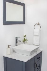 Un baño con un lavabo blanco y un espejo. en Location! Quality! Comfort! The downtown Gem, en Naples