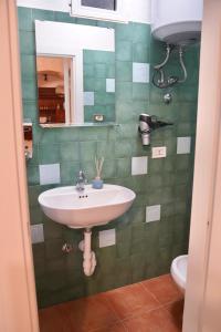 a bathroom with a sink and a mirror and a toilet at Affittacamere Casa nella grotta in Laterza