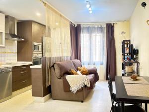 salon z kanapą i stołem w kuchni w obiekcie URBAN BEACH Grupo AC Gestion w Kadyksie +10 zdjęć