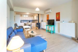 a living room with a blue couch and a kitchen at Ilios house in Achladies