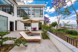 大理古镇Dali Blue House Sea View B&B的一个带椅子和遮阳伞的户外庭院
