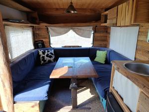 a living room with a blue couch and a table at la cabane mobile in Beyssenac