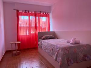 a bedroom with a bed and a red window at Apartamento Asturiano en Pravia in Pravia