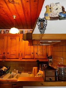 a kitchen with wooden cabinets and a sink and a stove at Petit Chalet De Montagne in Thorame-Basse