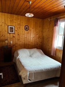 a bedroom with a bed in a wooden room at Petit Chalet De Montagne in Thorame-Basse