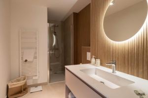 a bathroom with a sink and a mirror at Valras-Loc Panarea Duplex avec vue mer, spa in Valras-Plage