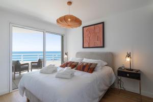 a bedroom with a bed with a view of the ocean at Valras-Loc Panarea Duplex avec vue mer, spa in Valras-Plage