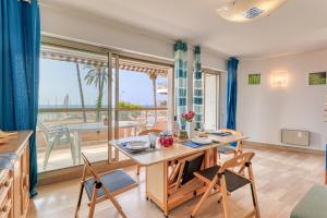 芒通Port & Pool Hideaway - Happy Rentals的一间带桌椅和阳台的餐厅